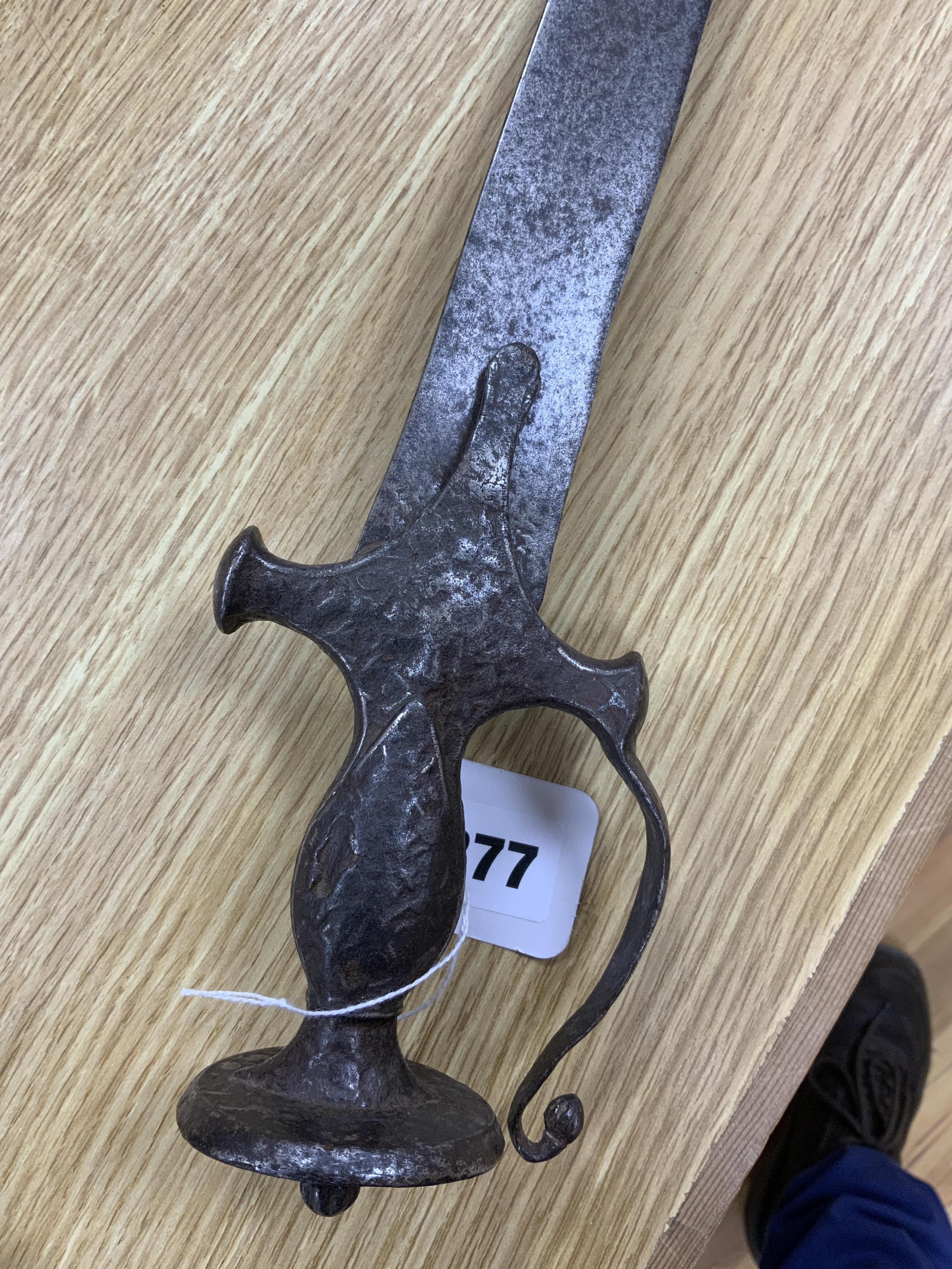 An Indian sword tulwar, the iron hilt with traces of chiselled and inlaid decoration, together with a kukri in its wooden scabbard, a Syrian jambya and a Moroccan jambiya (4)